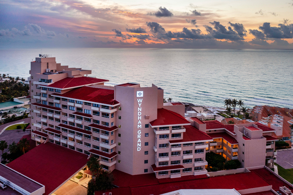 Wyndham Grand hotel en la playa con vistas al amanecer. Wyndham Grand Cancún All Inclusive Resort & Villas