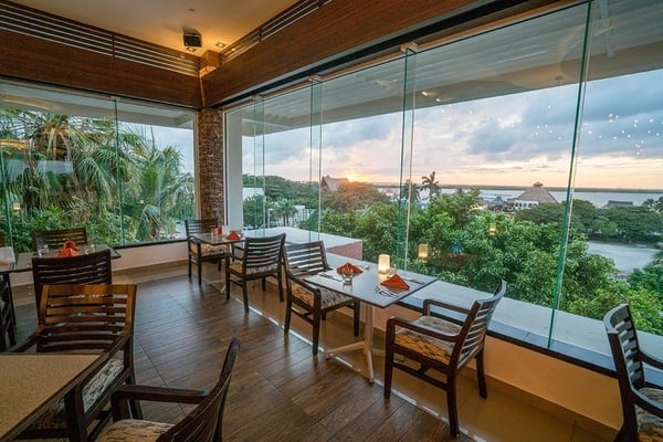 un restaurante con mesas y sillas y una vista del atardecer