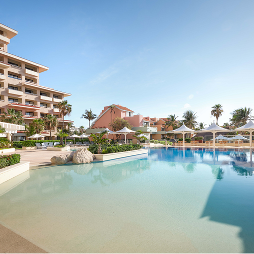 a large swimming pool in front of a hotel