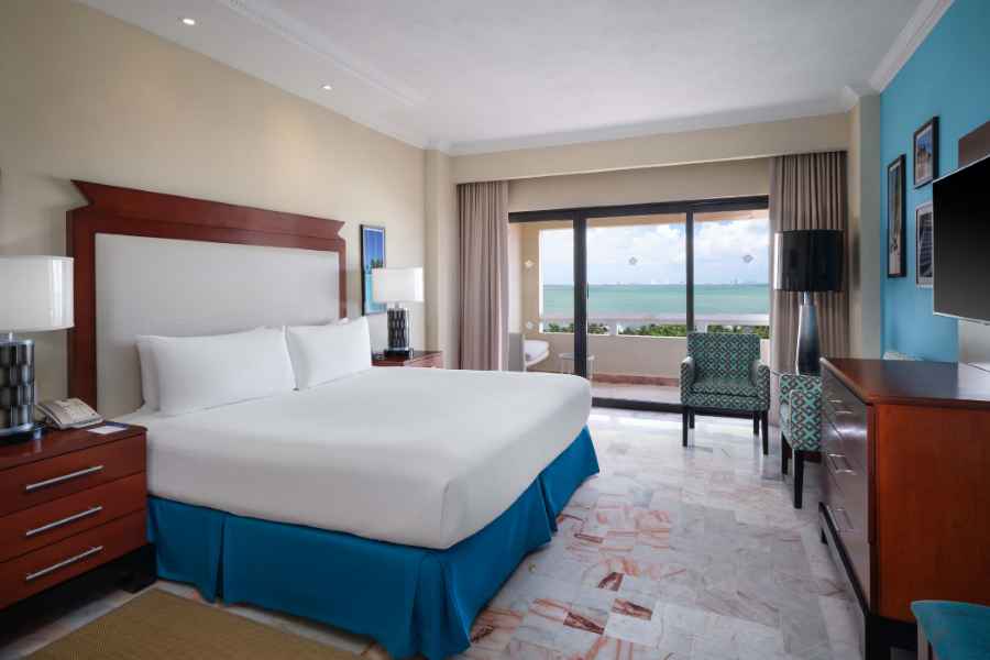 una habitación de hotel con una cama king size y una vista al océano