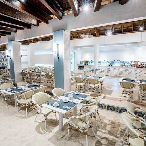 a dining room with tables and chairs and a buffet