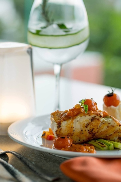 a plate of food with a glass of water in the background