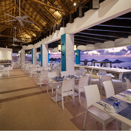a restaurant with tables and chairs and a view of the ocean