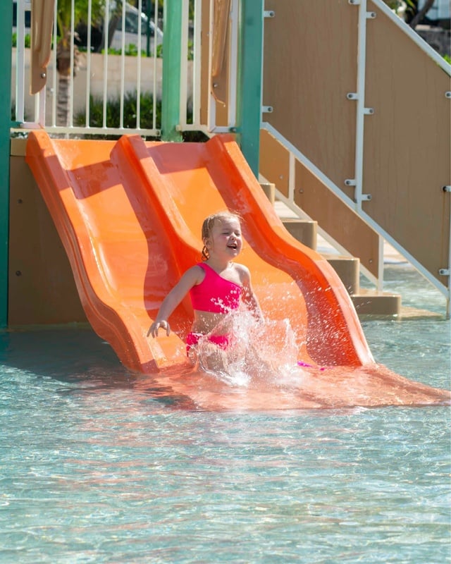 a bride and groom pose for a picture on the beach