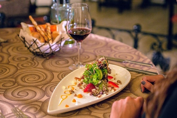 una mesa con un plato de comida y un vaso de vino