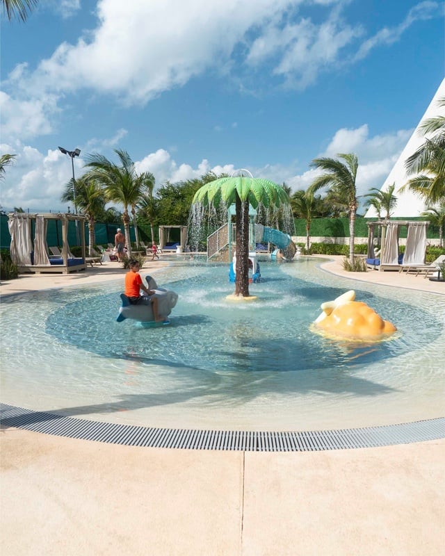 a bride and groom pose for a picture on the beach