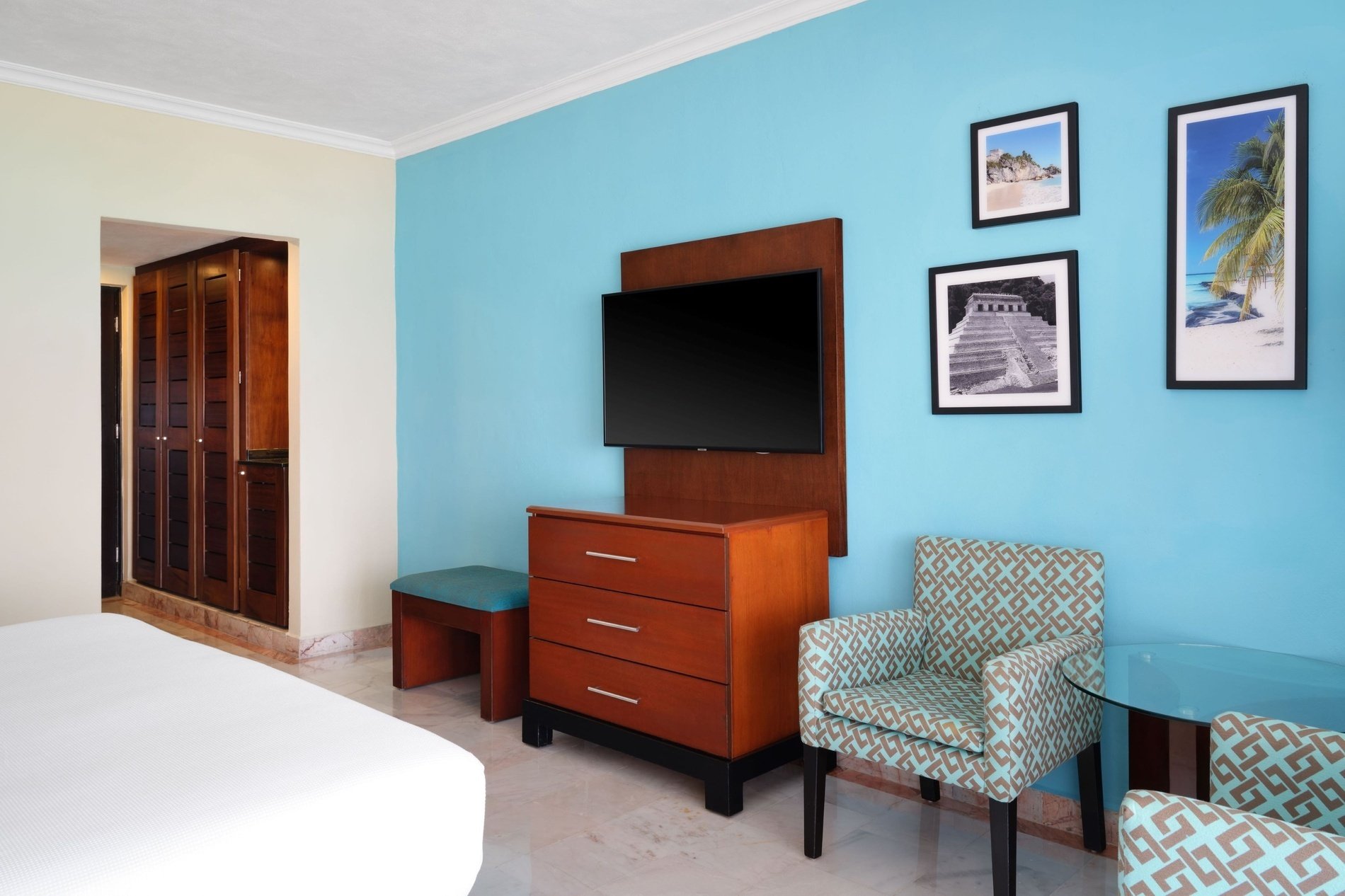 a hotel room with blue walls and a flat screen tv