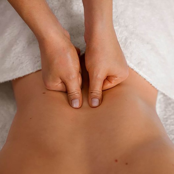 una mujer recibe un masaje en la espalda con sus dedos .