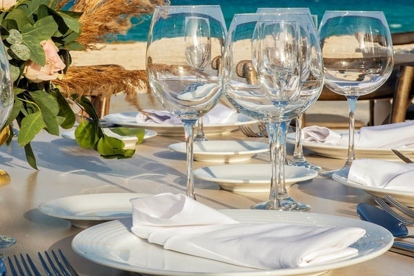 una mesa está decorada con platos y copas de vino