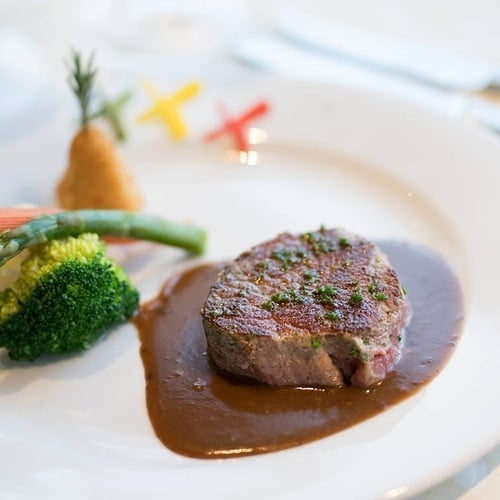 a white plate with a steak and broccoli on it