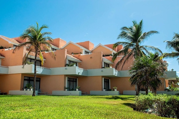 un edificio de color naranja con balcones y palmeras