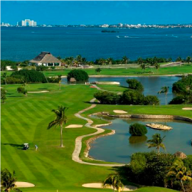 una vista aérea de un campo de golf con el océano al fondo