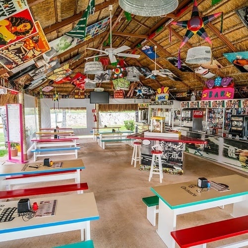 a restaurant with tables and benches and a sign that says 