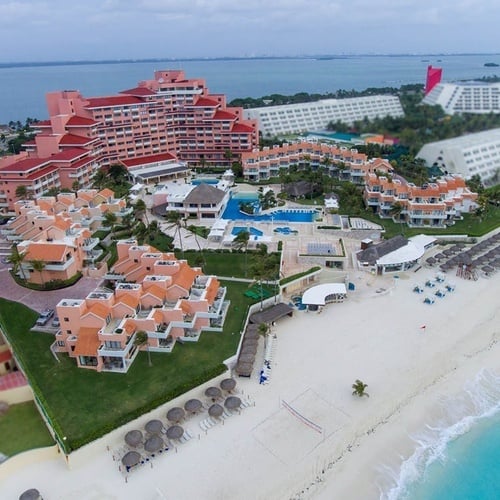 an aerial view of a resort with a large red building in the middle