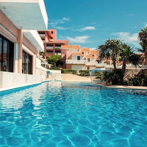 a large swimming pool with a building in the background
