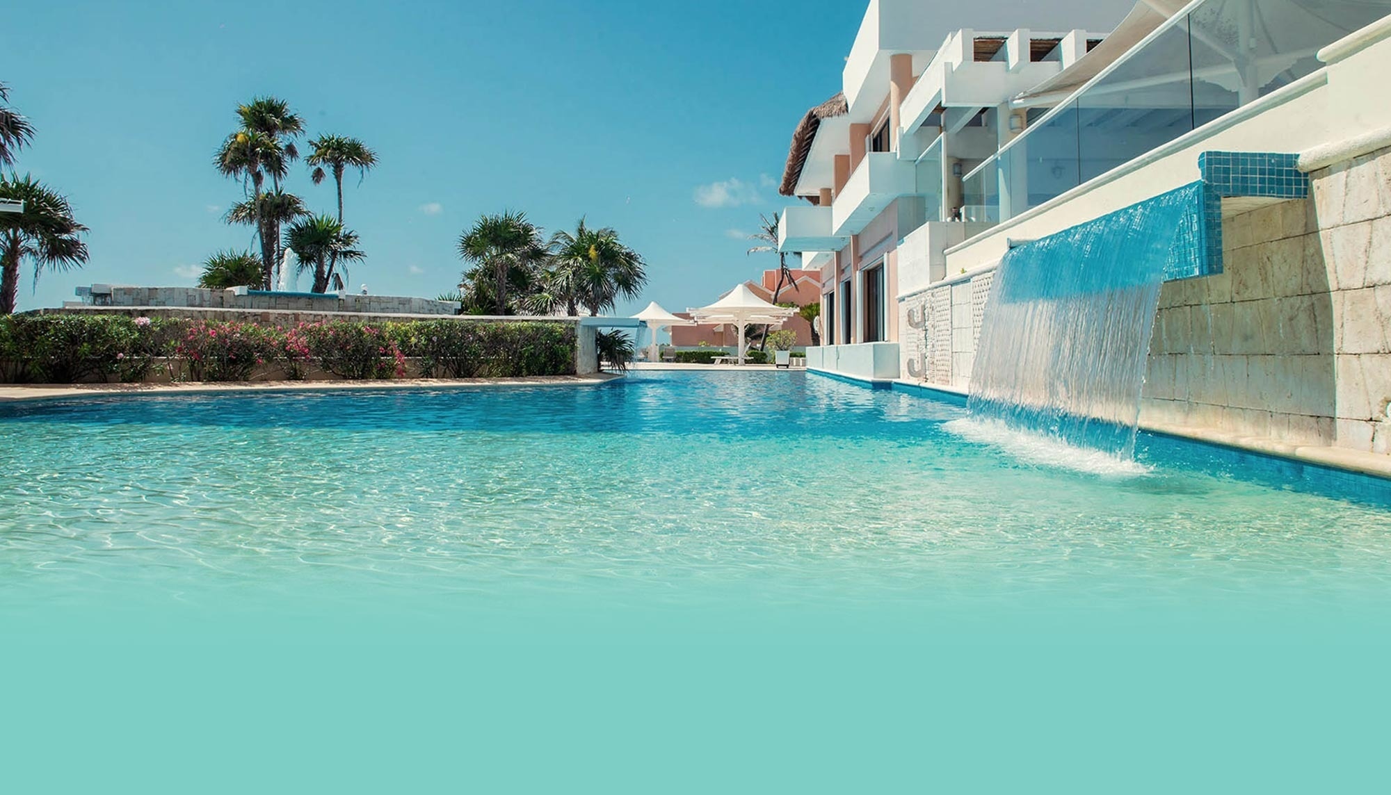  una piscina con una cascada y un restaurante en el fondo