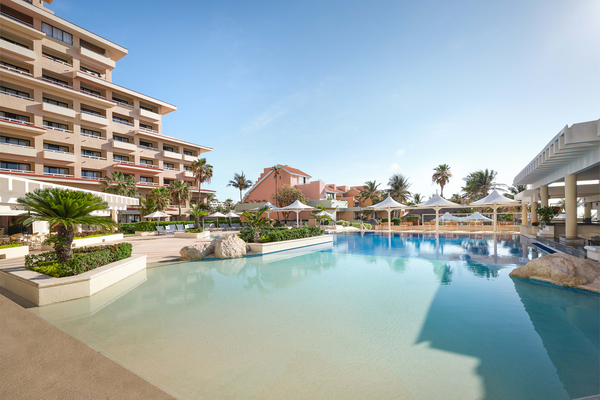 a large swimming pool in front of a hotel