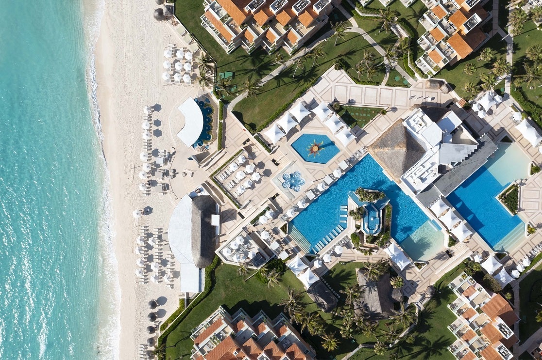 una vista aérea de un resort con piscinas y una playa