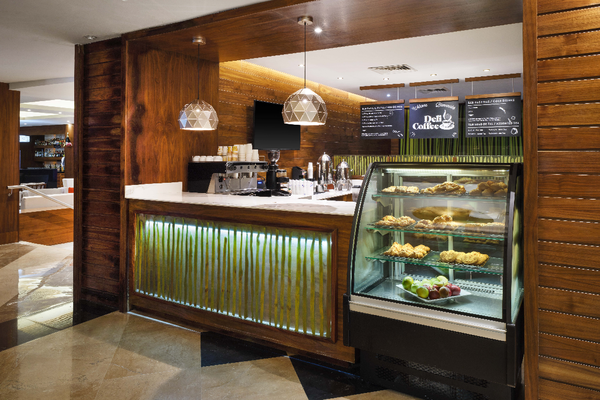 una cafetería con un mostrador de comida y una pizarra que dice deli & coffee