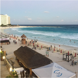 una vista aérea de una playa con un edificio en el fondo