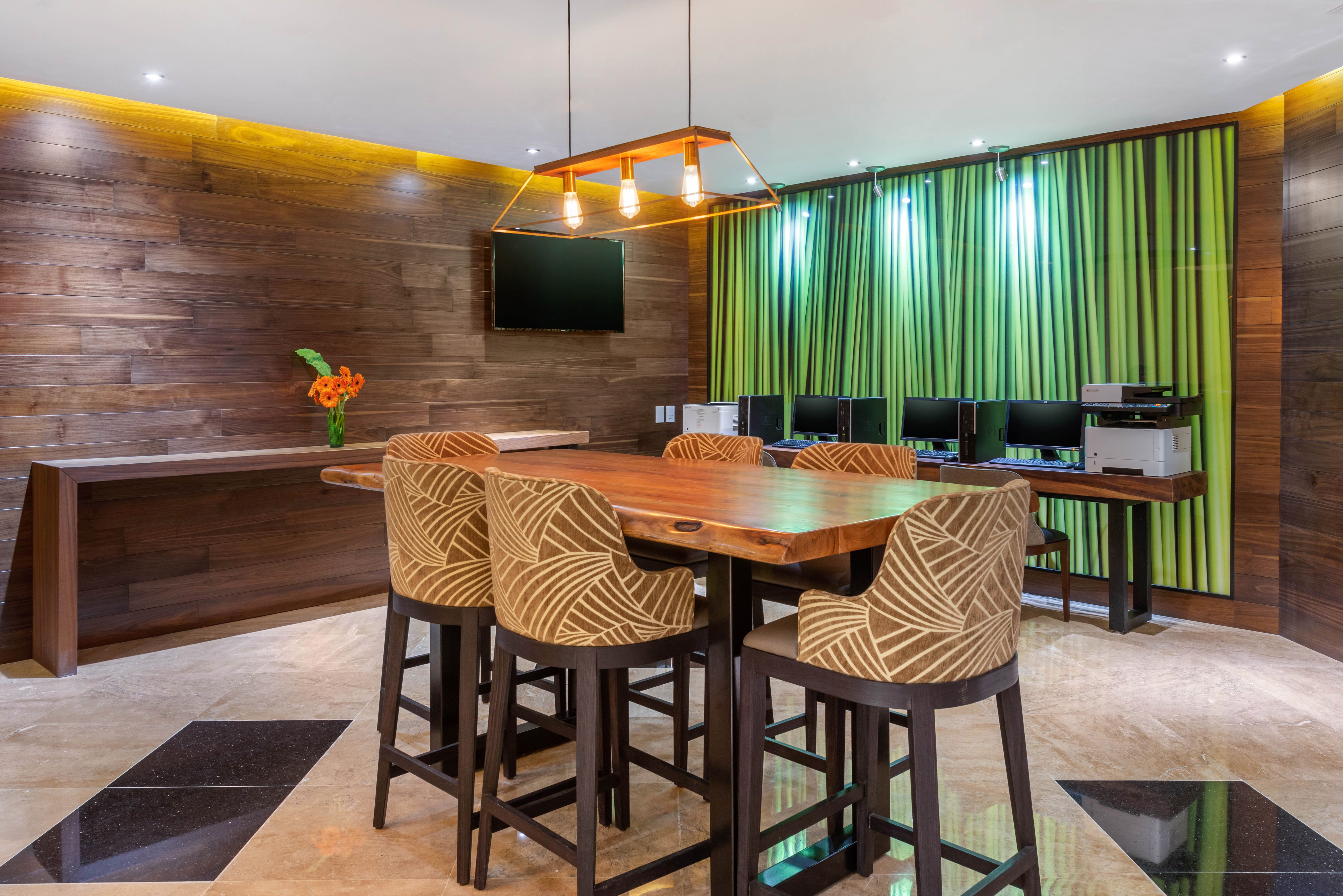 Wyndham Grand Cancún All Inclusive Resort & Villas: business center con mesas de madera, sillas modernas y área de computadoras.