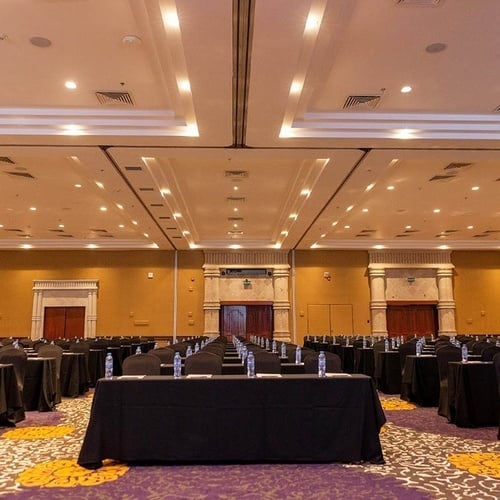 a large conference room with rows of tables and chairs