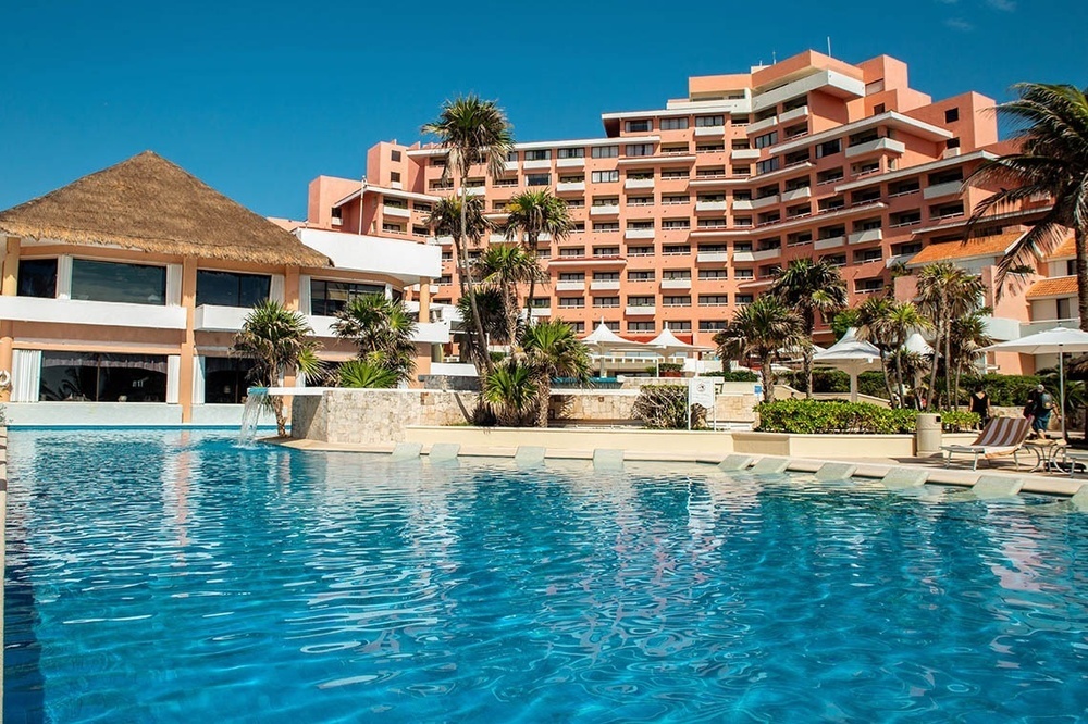 a large hotel with a large pool in front of it