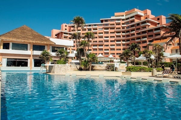 a large hotel with a large pool in front of it