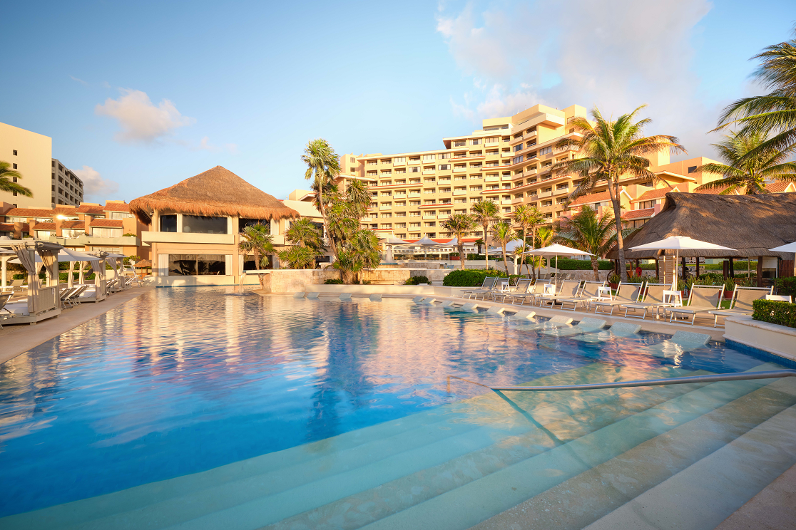 a large swimming pool in front of a hotel