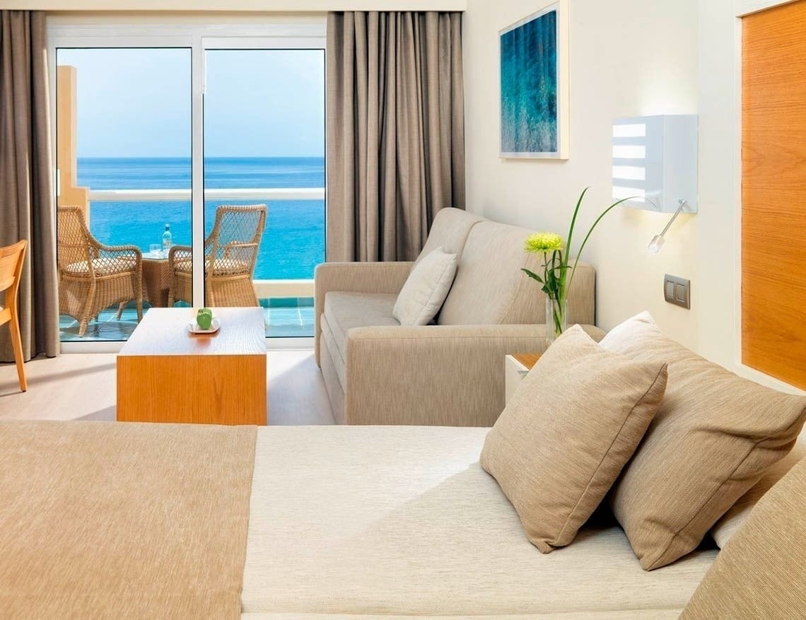 une chambre avec un canapé et une table avec une vue sur l' océan