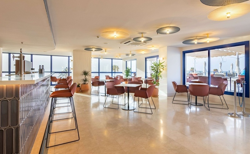 une salle à manger avec des chaises rouges et un bar