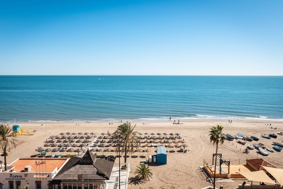 una playa con un restaurante llamado riviera en el primer plano