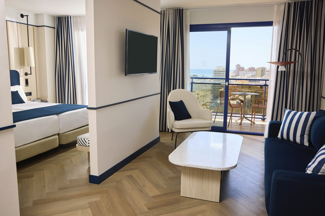 Modern hotel suite with two beds, a living area, and ocean view Yaramar.