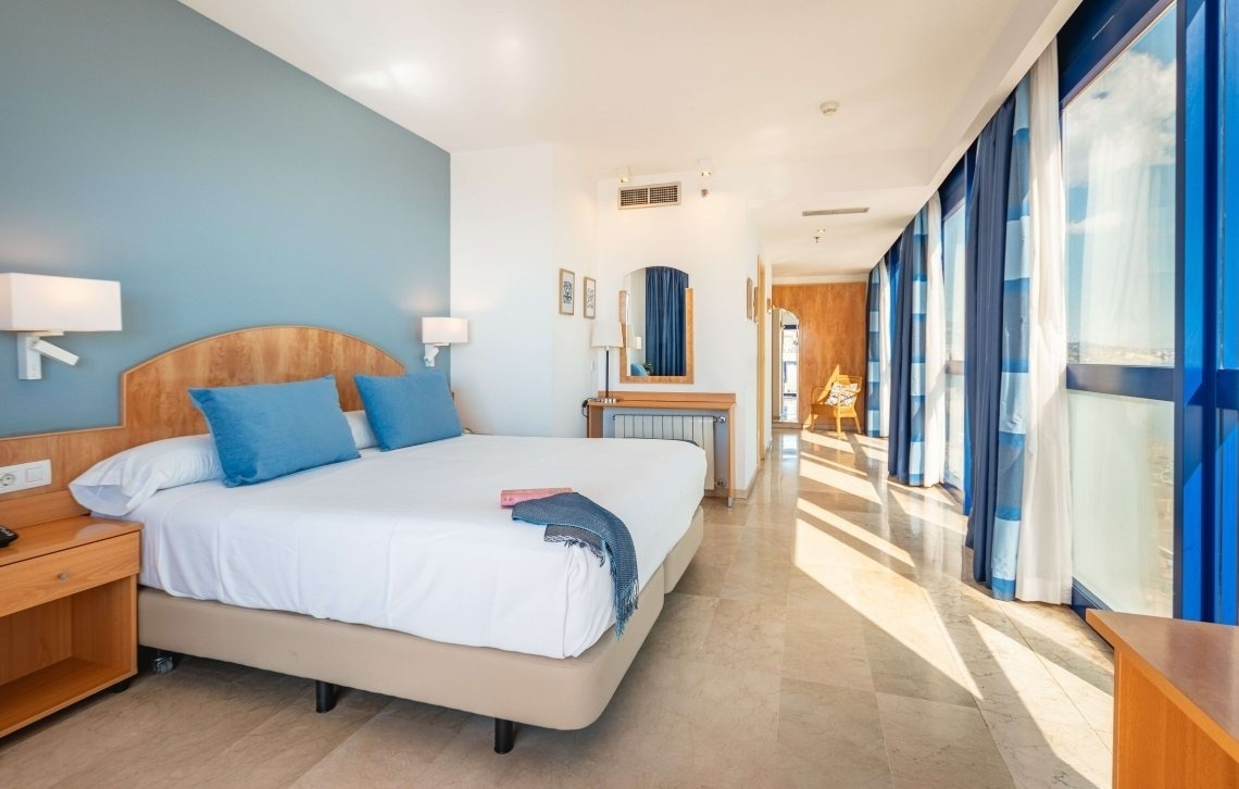 a hotel room with a large bed and blue curtains