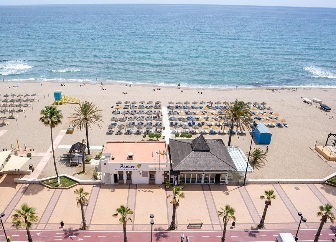 an aerial view of a beach with a rivera building in the foreground