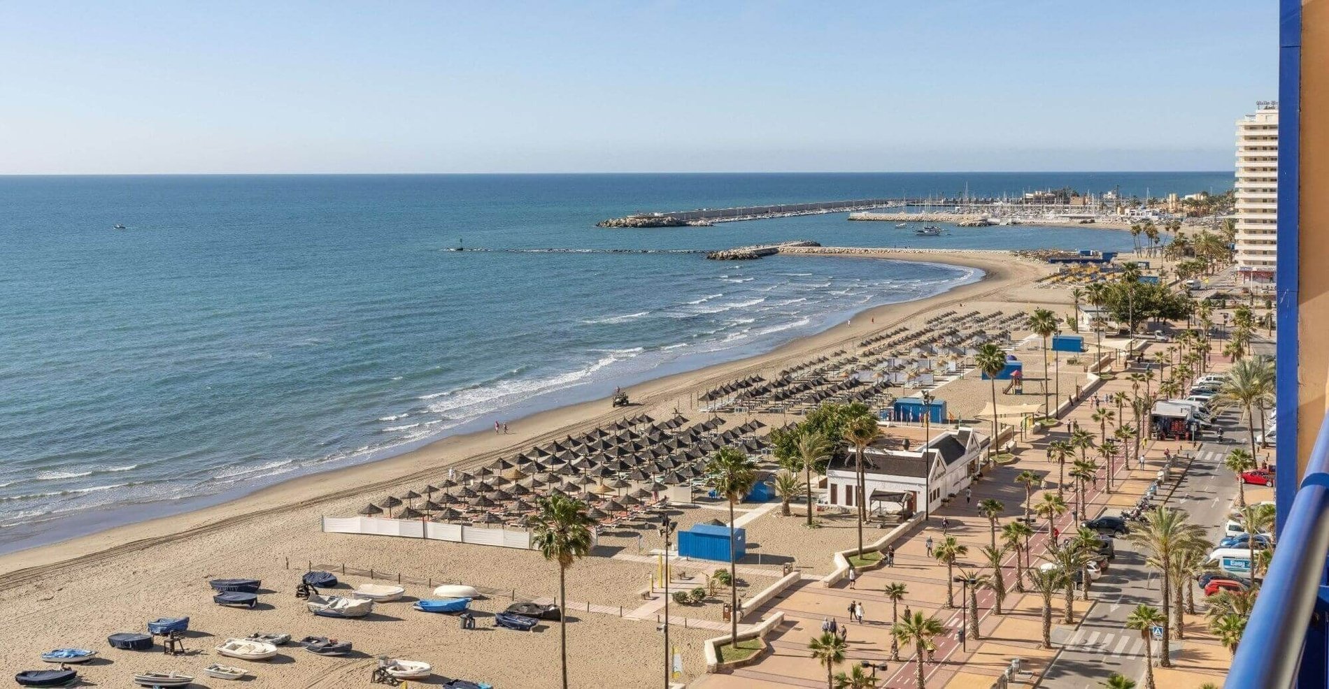 une vue aérienne d' une plage avec des parasols et des bateaux