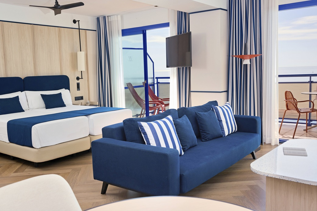 Modern hotel room with blue sofa, bed, and ocean view balcony. Rooms | Hotel Yaramar | Fuengirola | Malaga | Official Web