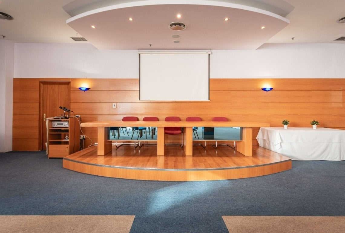 a conference room with a table and chairs and a projector screen