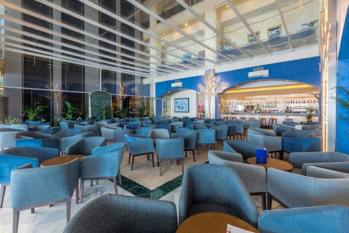 a restaurant with blue chairs and tables and a bar