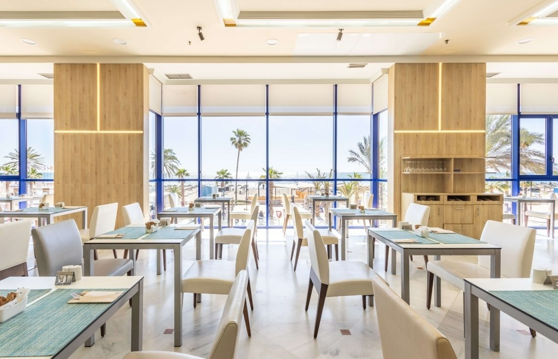 une salle à manger avec des tables et des chaises et une vue sur l' océan