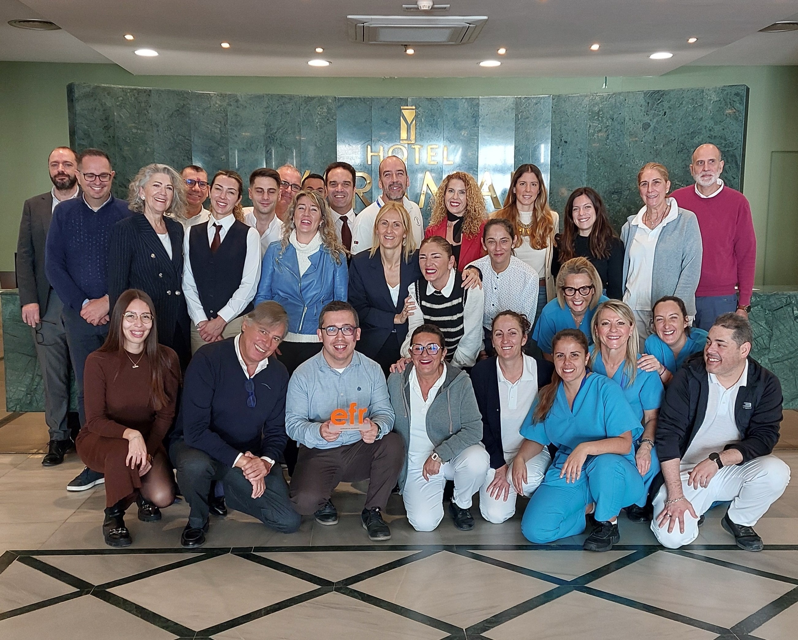 un groupe de personnes pose pour une photo dans un hall d' hôtel