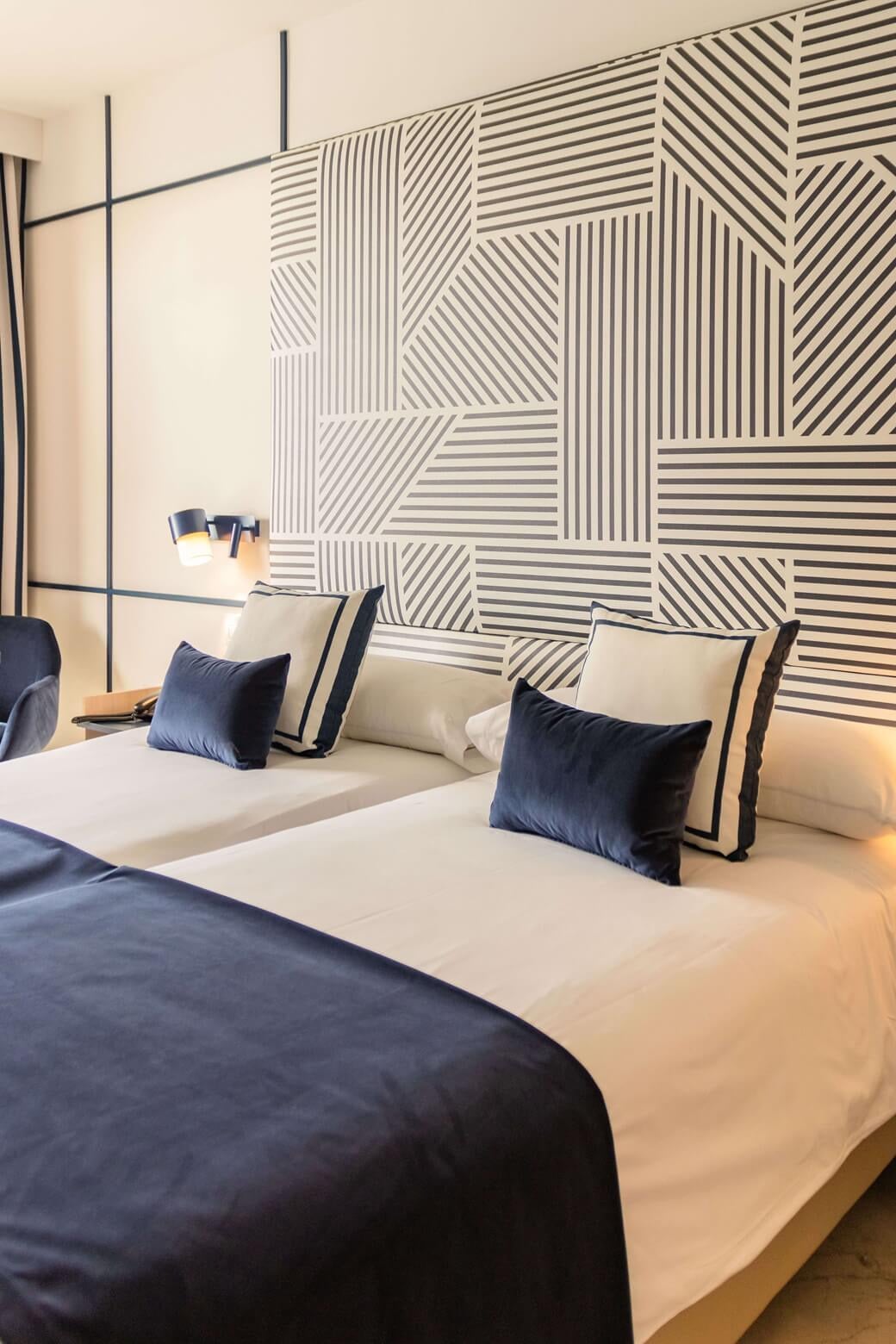 Modern Yaramar room with twin beds, TV, and balcony access.