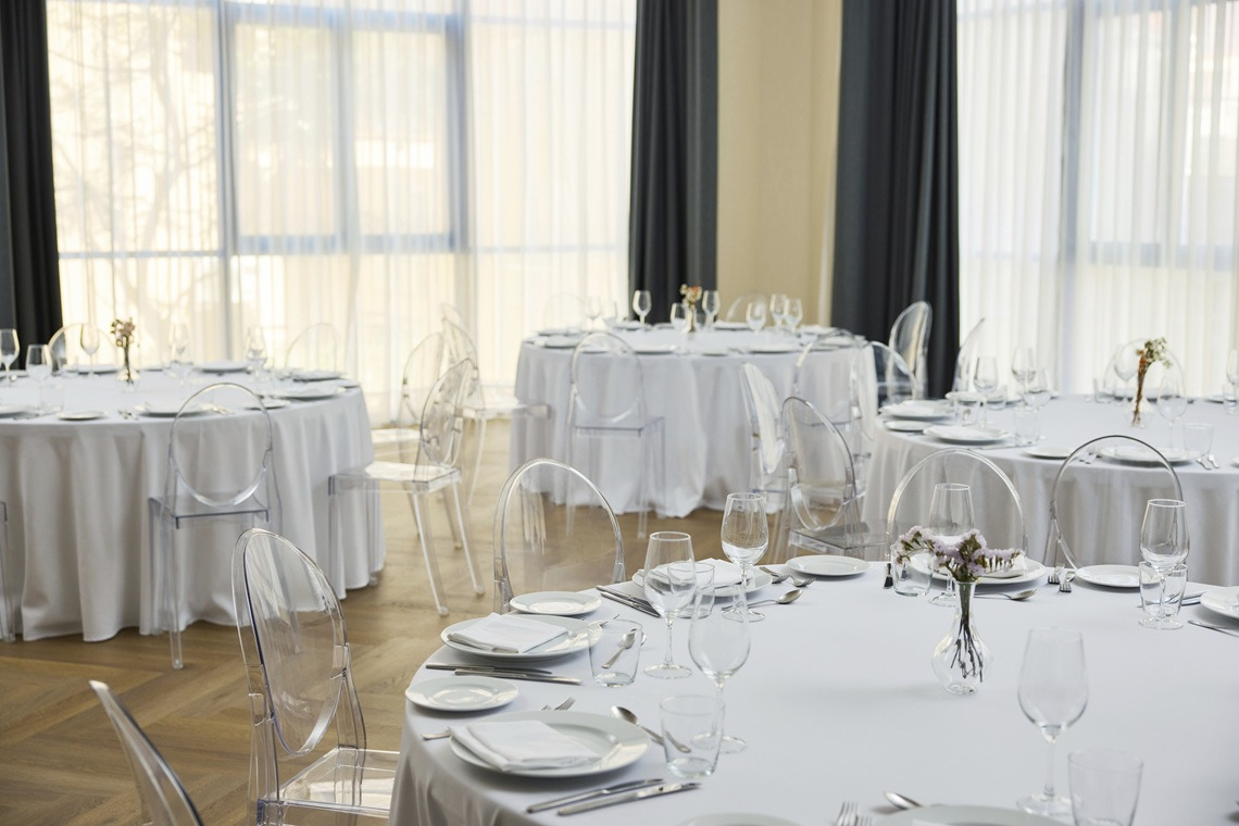Alboran Room Event hall for banquets in a hotel with round tables and transparent chairs, ideal for your Yaramar.