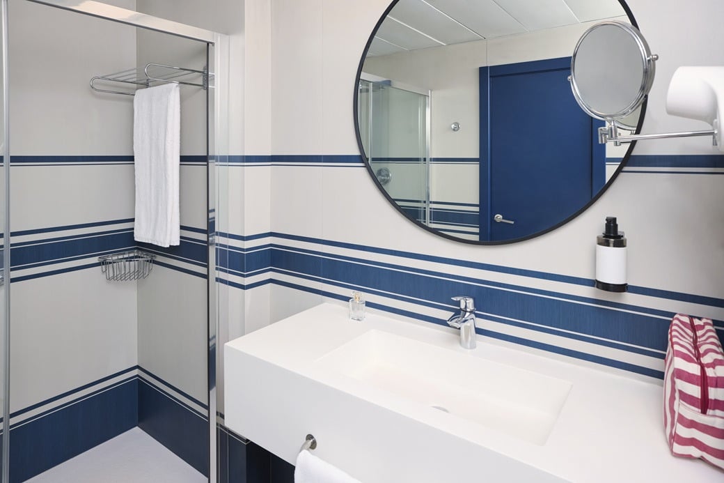 Modern hotel bathroom with sink, shower, and Yaramar.
