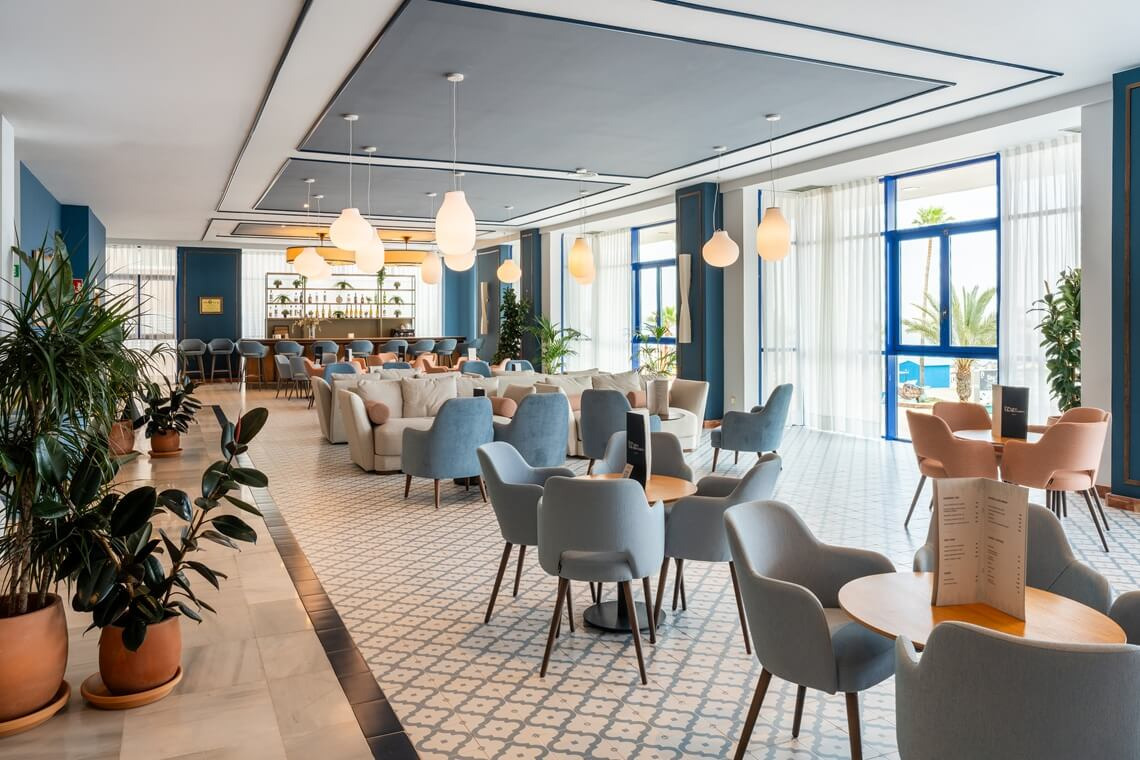 Mediterráneo Lounge Bar, a modern lounge with sofas and tables for Yaramar, with natural light and exterior views.