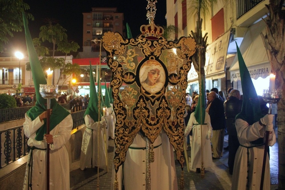 a group of people holding candles in front of a sign that says plaza relojeria