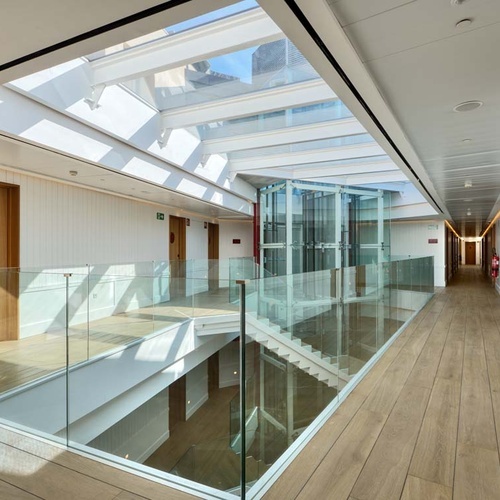 Modern Ybarra Sevilla hotel hallway with skylight, glass and elevator.