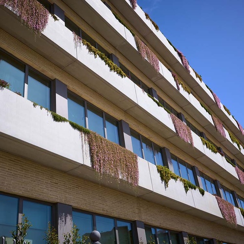Modern hotel facade with balconies and hanging plants at Ybarra Sevilla
