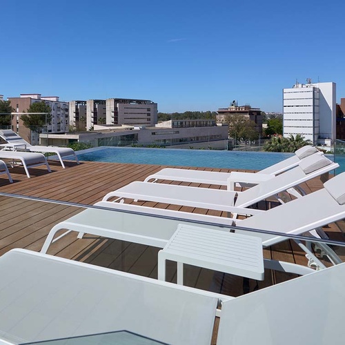 Luxury rooftop pool with sun loungers at Ybarra Sevilla, overlooking the city.