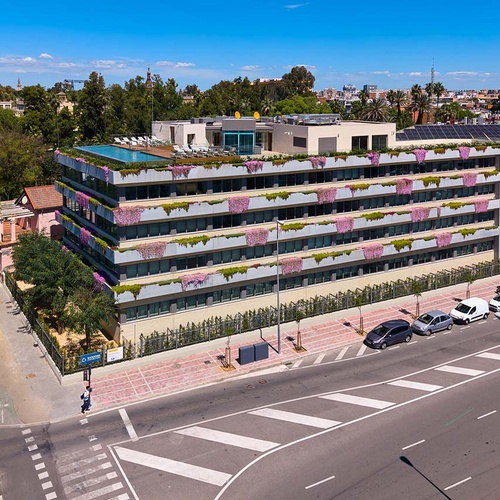 Modern Ybarra Sevilla hotel with rooftop pool and floral balconies.